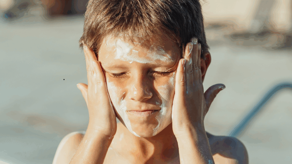 Kid applying suncreen
